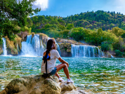 KRKA waterfalls Croatia, krka national park Croatia on a bright summer evening, woman relaxing in the park